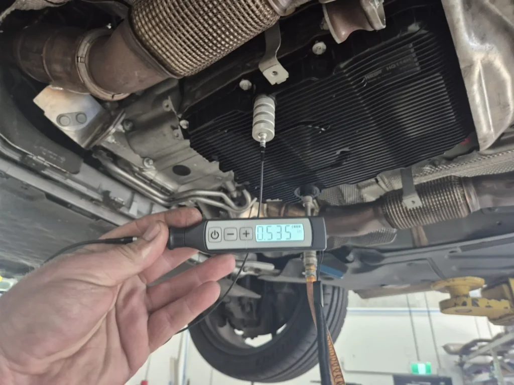 The ultrasonic probe fitted to the transmission sump to measure the fluid height without opening a conventional level plug.