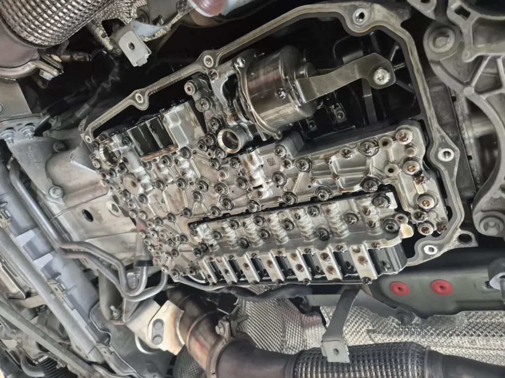 The internal valve body and transmission components exposed during a Mercedes-Benz transmission fluid and filter service.