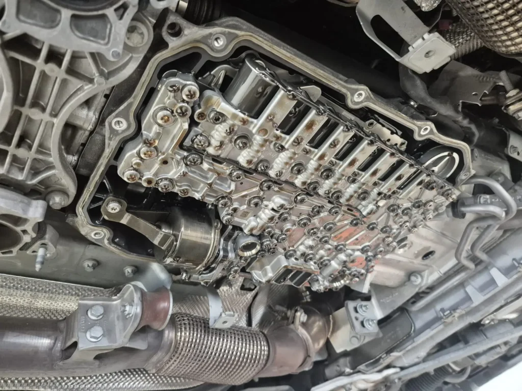 The internal valve body and transmission components exposed during a Mercedes-Benz transmission fluid and filter service.