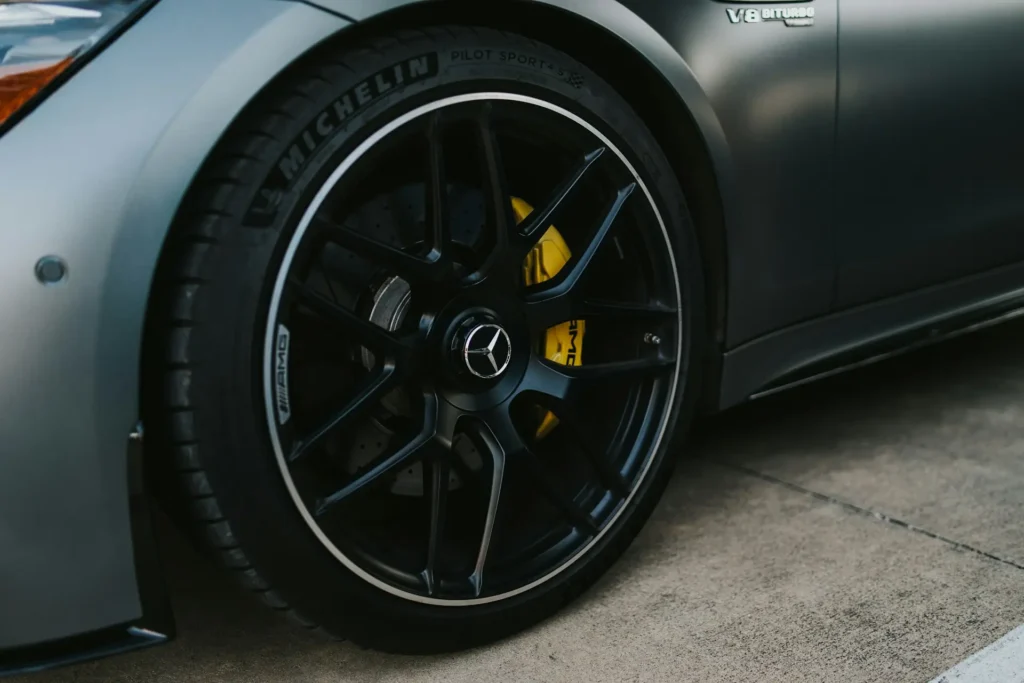 Yellow AMG multi-piston brake caliper and drilled disc on a Mercedes-AMG V8