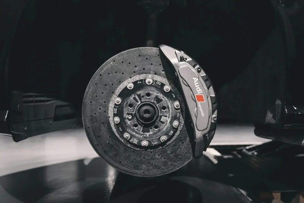 Audi carbon ceramic brake disc and caliper with the wheel removed in a workshop