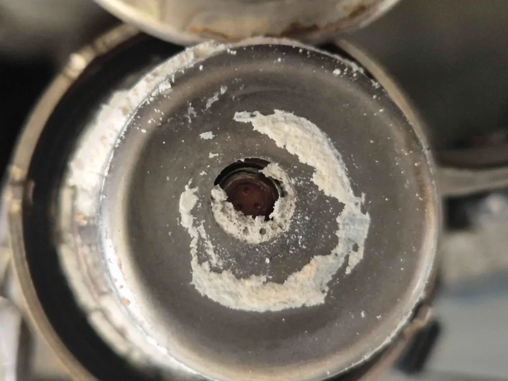 Faulty Mercedes AdBlue injector (metering valve) crusted with hardened urea deposits inside the exhaust